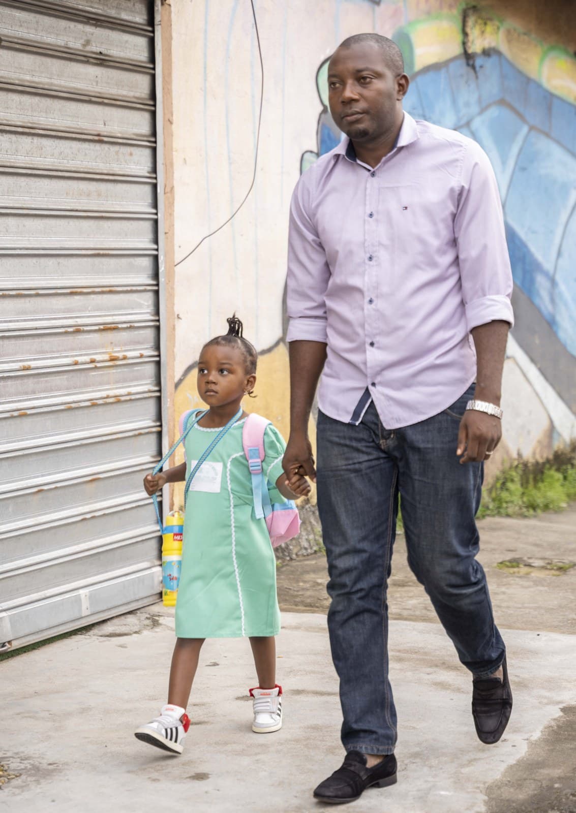 Un père accompagnant sa fille à l'école
